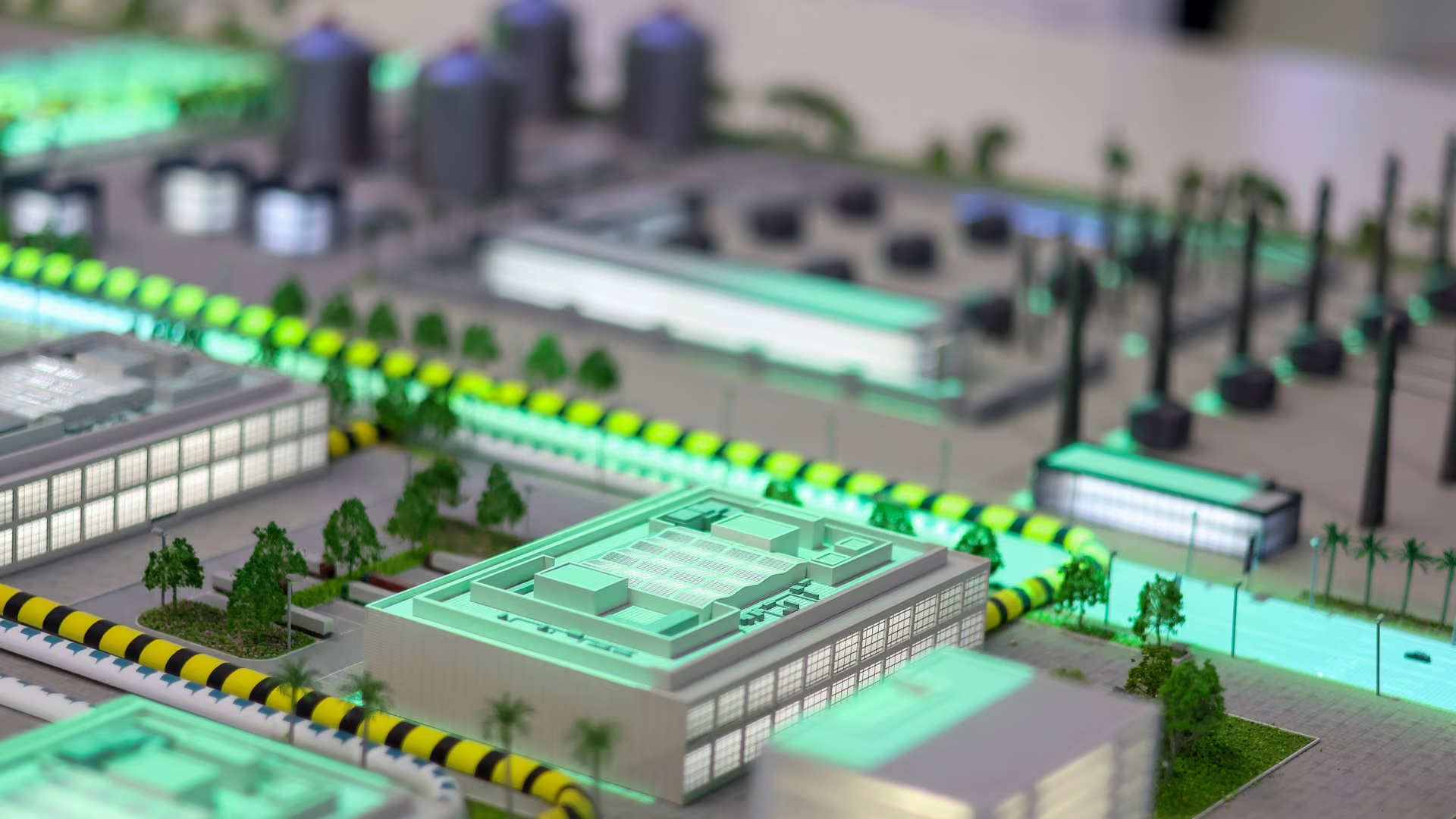 Illuminated three-dimensional model of an industrial campus, showing buildings, roads, storage tanks and site infrastructure
